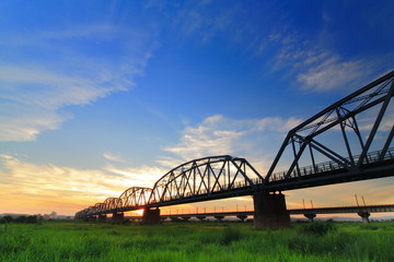 beautiful sunset with old bridge and green grass