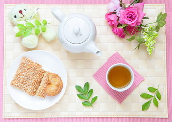 Obraz na płótnie Canvas leisurely tea time with cookie, cute bear and beautiful flowers