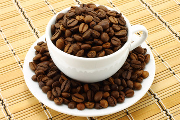 Coffee cup with beans on a wooden background