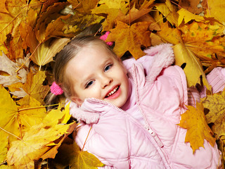 Naklejka na ściany i meble Kid in autumn orange leaves.