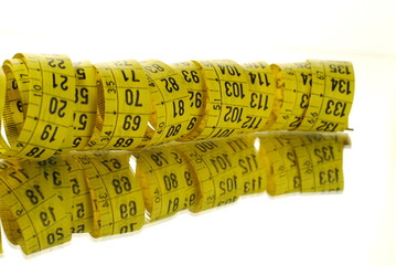 measuring tape over a mirror on white background