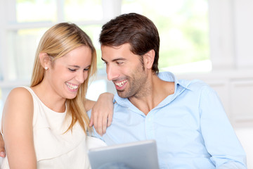 Young couple using electronic tablet at home