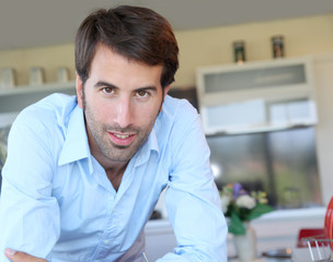 Fototapeta premium Smiling man standing in domestic kitchen