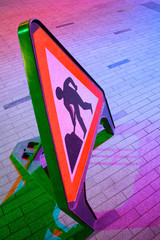 Colourful roadworks triangle sign; workman and shovel symbol