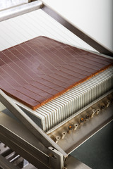 Machine d&eacute;coupant une plaque de barres chocolat&eacute;es