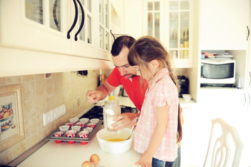 Father and daughter cooking togehter in kitchen