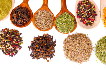 spices in the spoons isolated on white