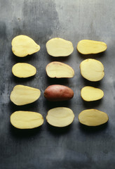 Pommes de terre coupées en deux et une pomme de terre rose entière