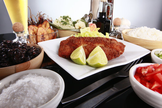 Breaded fish with staple caribbean sides, rice and beans