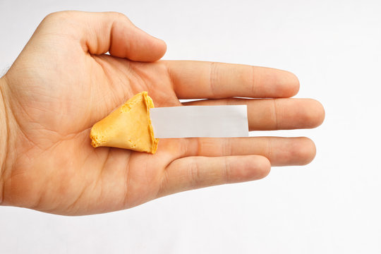 Half of a fortune cookie in a hand with a blank fortune