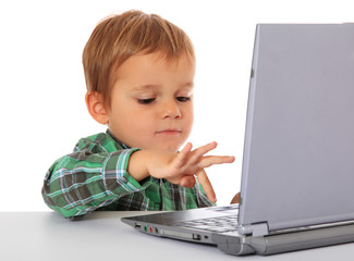 Kleiner Junge spielt mit Laptop