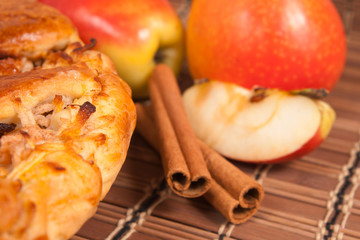 Apple pie with fresh apples and cinnamon sticks
