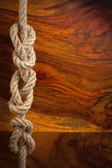 Fototapeta na wymiar Knot liny na tle drewna tekowego