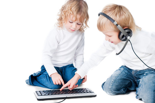 two children playing with computer on floor