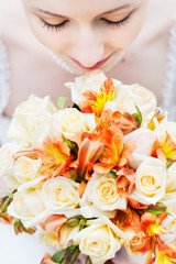 Bride holding beautiful orange wedding flowers bouquet