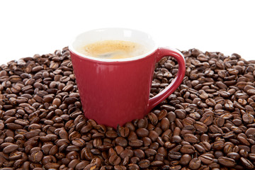 red coffee cup on pile of beans
