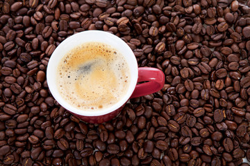 coffee cup in background of beans