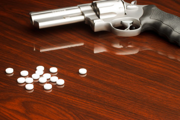 .357 revolver laying on wooden surface with drugs