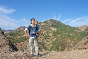 Young man with digital camera on top of the Karadag mountain, Na