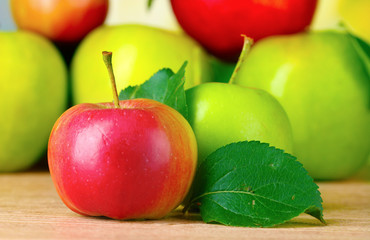Many fresh organic apples on wooden table