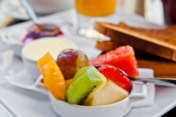 Breakfast with orange juice and fresh fruits on table