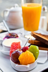 Breakfast with orange juice and fresh fruits on table
