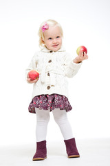 Blonde girl holding at arm's length red apple