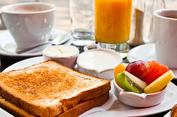 Breakfast with orange juice and fresh fruits on table