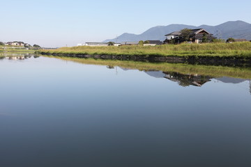 鏡のような川面と河畔の景色