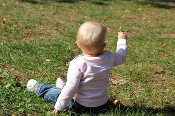 Kleines Mädchen sitzt im Gras