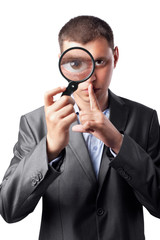 businessman in a suit looking through a magnifying glass