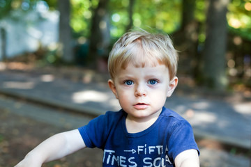 Adorable baby boy with blue eyes and blond hairs