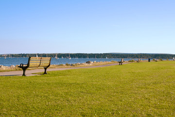 Row of wooden benchces face outwards to sea
