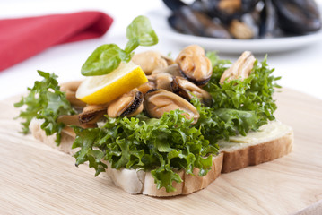 Gekochte Miesmuscheln mit Zitrone und frischem Salat auf Toast