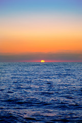 blue sea sunrise with sun in horizon