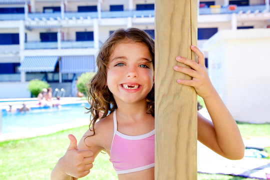 indented kid girl ok gesture in pool garden