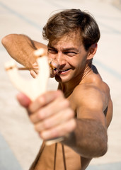 Man holding slingshot outdoors