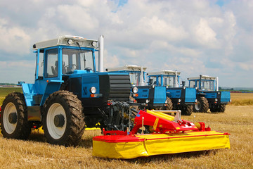 Group of powerful tractors on the field