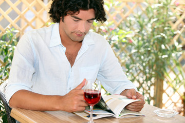 Man drinking wine on restaurant terrace
