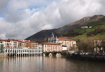 Fototapeta na wymiar View of Tolosa, Oria river, town market and Santa Maria Church