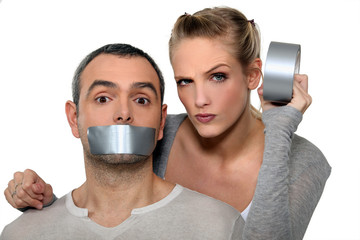 Woman taping-up mans mouth - obrazy, fototapety, plakaty