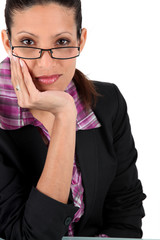 Businesswoman peering over her glasses