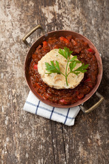 Gulasch mit Knödel auf einem Holzbrett