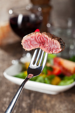 Steak auf einer Gabel über den Salat