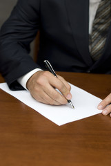 Businessman's hand writing on white sheets