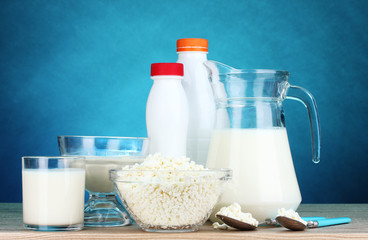 Dairy products on wooden table on blue background