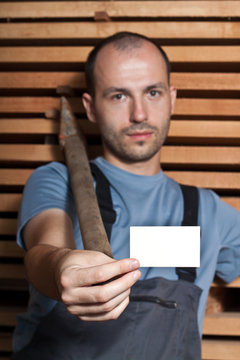 Craftsman with a hammer holding a business card