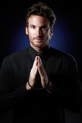 Priest praying with rosary