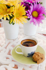 Ceramic cup of coffee with yellow and purple flower