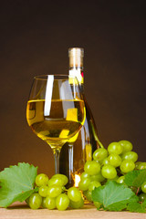 Glass of wine,bottle and grapes on yellow background